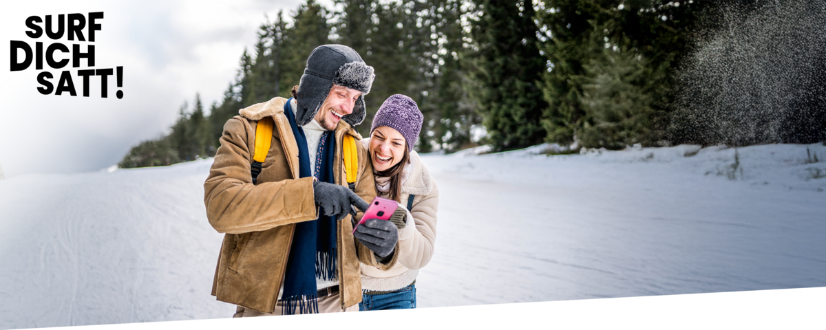Paar im Winter-Outfit freut sich über ihren neuen Handytarif ohne Handy