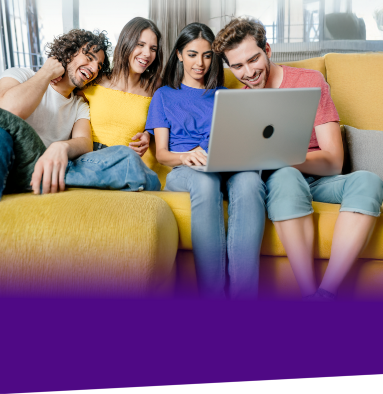 Eine Gruppe von Freunden lachen während sie auf einen Laptop schauen.