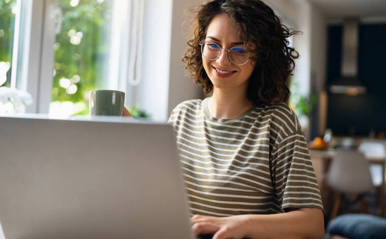 Das Bild zeigt eine Frau mit Laptop