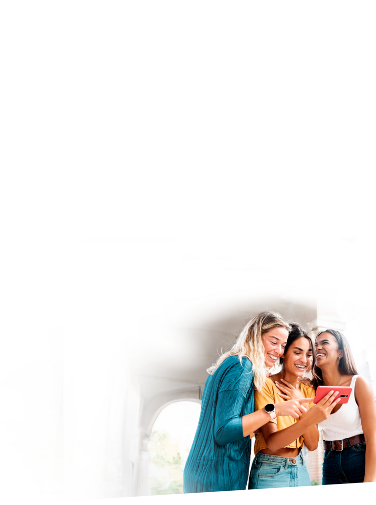 Drei junge Frauen stehen lachend um ein Smartphone und nutzen den neuen Mobilfunkvertrag von sim24.