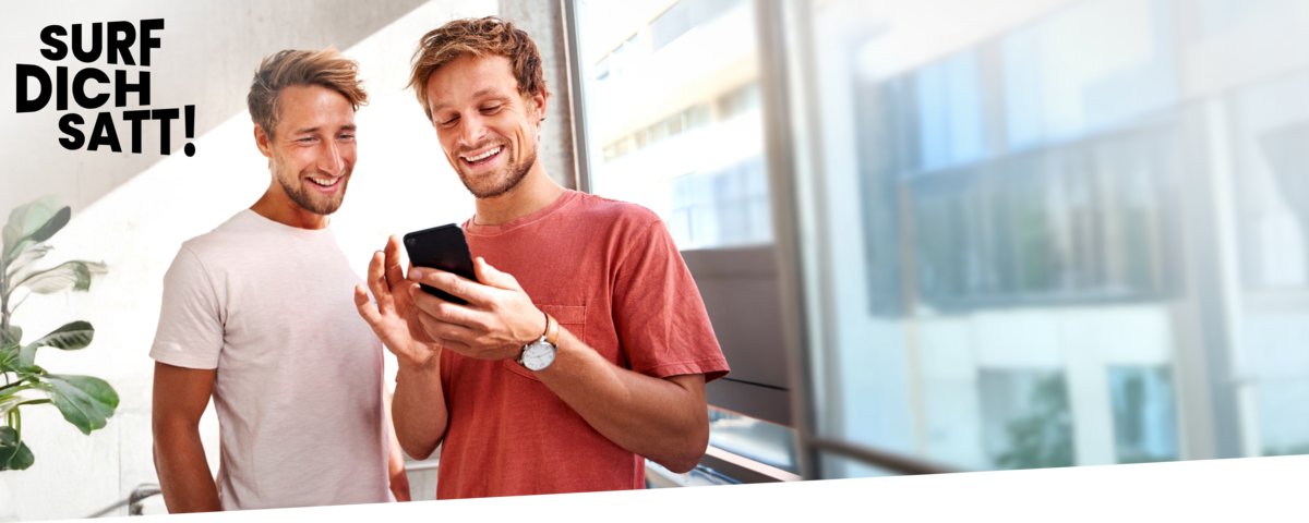 Ein Mann zeigt seinem Freund auf dem Handy günstige Handyverträge.